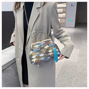 Dettaglio di una borsa a mano vintage in tessuto ricamato con onde e nappa blu vivace