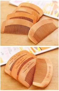 Detailed view of peach wood fine-tooth hair combs, showing smooth teeth and laser carved text.