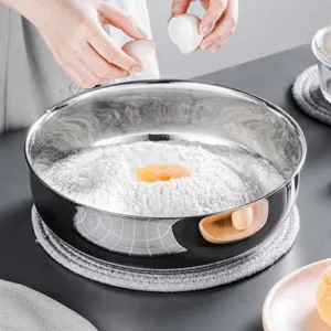Stainless steel mixing bowl detail showing deep capacity and flour preparation in kitchen scene.