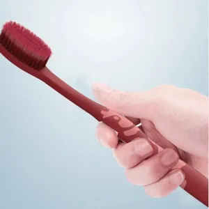 High-density soft bristle wide-head adult toothbrush held in hand, featuring a cute cow design.