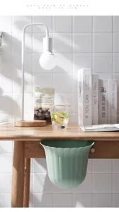 Vista detallada de un cubo de basura colgante con borde festoneado para cocina y baño.
