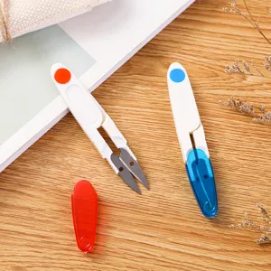 Close-up detail shot of portable thread snips with transparent protective cover, stainless steel.