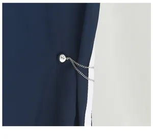 Detailed view of a magnetic pants cuff clip with sparkling rhinestones and delicate silver chain.