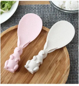 Close-up detail of cute standing rabbit rice spoon in wheat straw, non-stick kitchen tool.