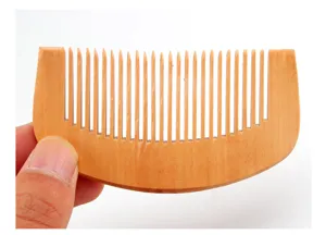 Fine-tooth wooden comb detail shot, showing natural wood grain and compact portable size structure.