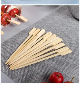 Detailed close-up shot of bamboo paddle skewers arranged neatly on a grey woven mat.