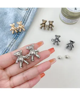 Detailed shot of cute teddy bear jeans waist tightening buttons, metal adjustable pin accessories.
