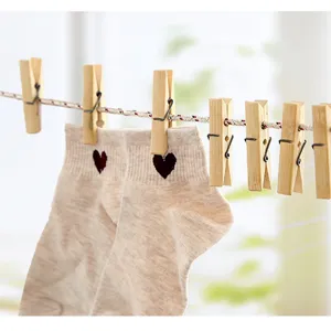 Natural wooden clothespins clipping socks on a laundry line, household utility hanging clips.