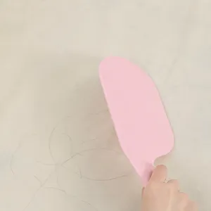 Pink plastic bedsheet cleaning scraper tool for easily removing hair and dust from bedding.