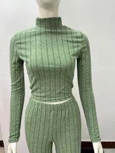 Green ribbed knit long sleeve crop top and matching trousers set detail view showing texture.