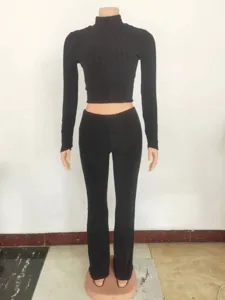 Close-up detail view of black ribbed knit long sleeve crop top and matching trousers set.