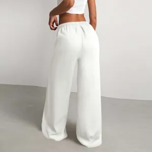 Vista posteriore dettagliata di pantaloni casual ampi testurizzati da donna in bianco.