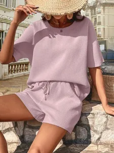 Detail of the pink waffle knit top and shorts set worn by model outdoors, casual style.