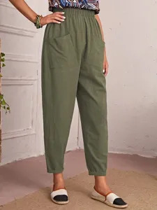 Detail view of casual cropped pants with elastic waist and large side pockets in olive green.