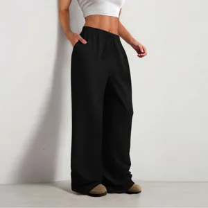 Dettaglio dei pantaloni casual neri a gamba larga con trama stropicciata e coulisse in vita.