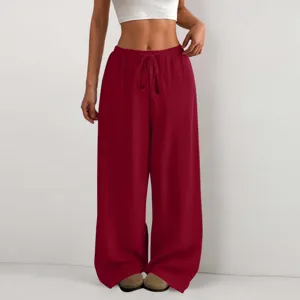 Dettaglio dei pantaloni casual da donna rossi ampi con gamba larga in tessuto crepe.