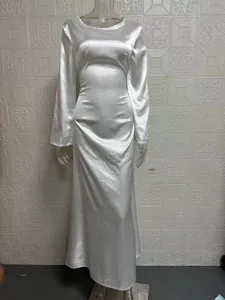 Detailed view of the elegant white long-sleeve satin maxi dress with slim-fit waist design.