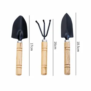Mini set tuingereedschap met houten handvatten voor planten en bloemen thuis.