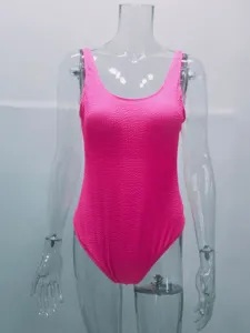 Neon pink crinkle textured one-piece swimsuit detail view showing unique wave fabric.