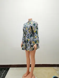 Detailed view of grey floral print long sleeve dress featuring ruffled tiered hem and half collar.