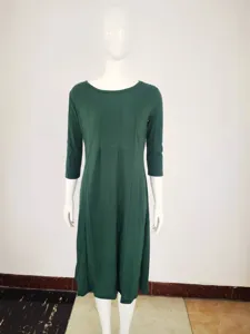 Detalle de vestido verde oscuro con cuello redondo, mangas tres cuartos y diseño de paneles.