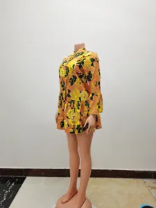 Detail view of orange floral long sleeve dress, showing pattern and half-collar design clearly.