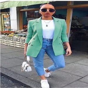 Detail view of a fashionable green double breasted lapel blazer jacket for women, stylish.