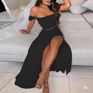 Close-up detail of stylish solid black off-the-shoulder crop top and high-slit long skirt.