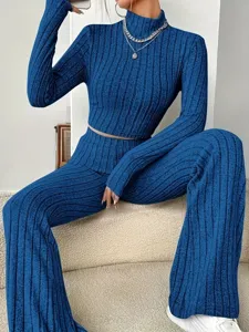 Close-up detail showcasing the stylish blue ribbed knit long sleeve crop top and flare pants set.
