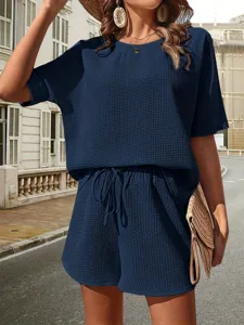Detailed view of women's dark blue waffle knit two piece set, batwing sleeve top and shorts.