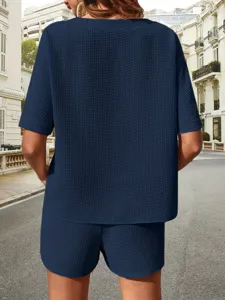 Detailed back view of women summer navy blue textured two-piece top and shorts outfit set.