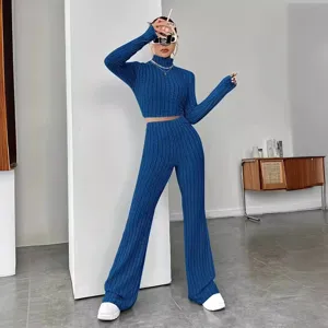 Blue ribbed knit two-piece set featuring long sleeve crop top and flared pants for women.