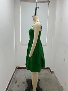 Green textured spaghetti strap mini dress detail view, summer casual tiered dress style.
