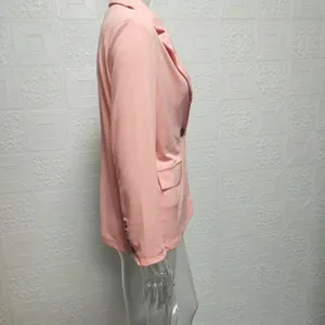 Side detail view of a solid pink slim-fit suit jacket on a mannequin, elegant office wear.
