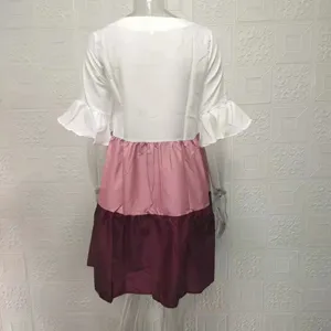 Back detail of a chic color-block dress with white ruffle sleeves, pink, and burgundy tiers.