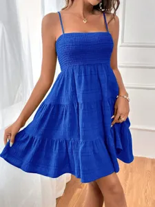 Detailed view of blue spaghetti strap smocked mini dress with tiered hem for women.