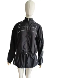 Women's black tracksuit set detail, long sleeve zip up jacket and matching shorts with white piping.