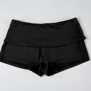 Detailed view of black athletic shorts, solid color fold-over waist, flexible sports fabric.