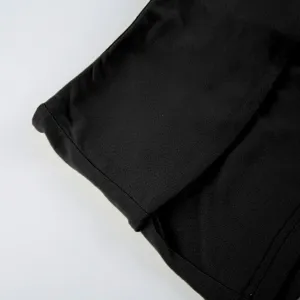 Close-up of black clothing fabric detail showing fine stitching and smooth texture.