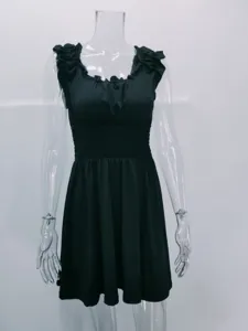 Vista dettagliata di un elegante abito estivo nero con volant sulle spalle e vita smockata.