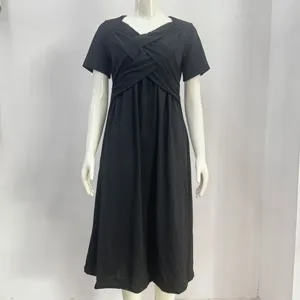 Black short sleeve dress detail showing the cross neckline and flared skirt design.