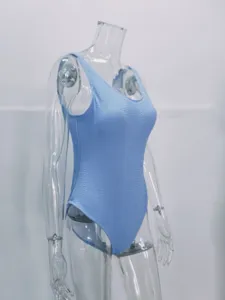 Detail view of light blue crinkle one-piece swimsuit, textured fabric, close-up.