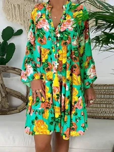 Boho style floral print long sleeve dress detail showcasing vintage green fabric and flowy hem.