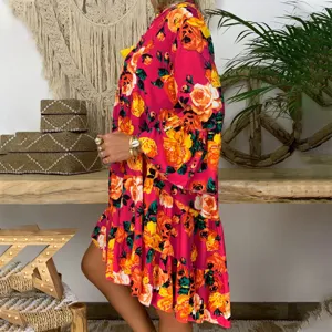 Detail view of a boho floral swing dress with half-open collar and vibrant pink print.