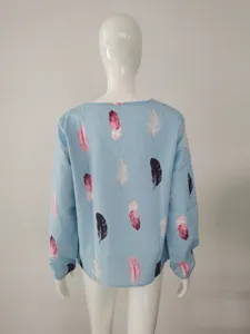 Back detail of women long sleeve light blue loose blouse featuring elegant feather print pattern.