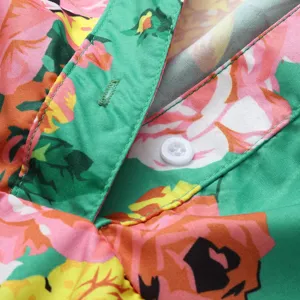 Close-up detail shot showing the floral print fabric, front button placket and collar design.