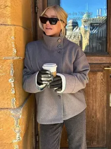 Détail de manteau en laine grise avec col montant et boutons chics, style de mode d'hiver.