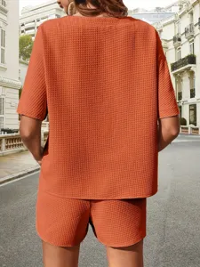 Detailed back view of women's casual textured two-piece set featuring short sleeves and shorts.