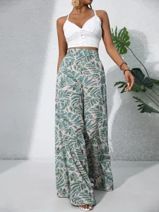 Chic summer tropical leaf print high waist wide leg pants paired with a stylish white crop top.