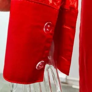 Red long sleeve jumpsuit cuff detail close up view, elegant apparel design showcase.